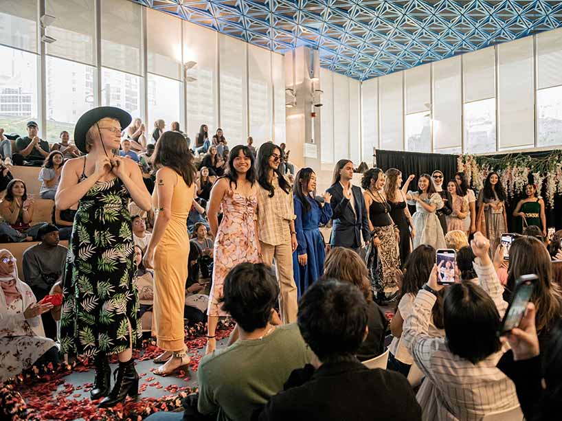 Students line up on a elevated runway with a range of outfits expressing their individual style