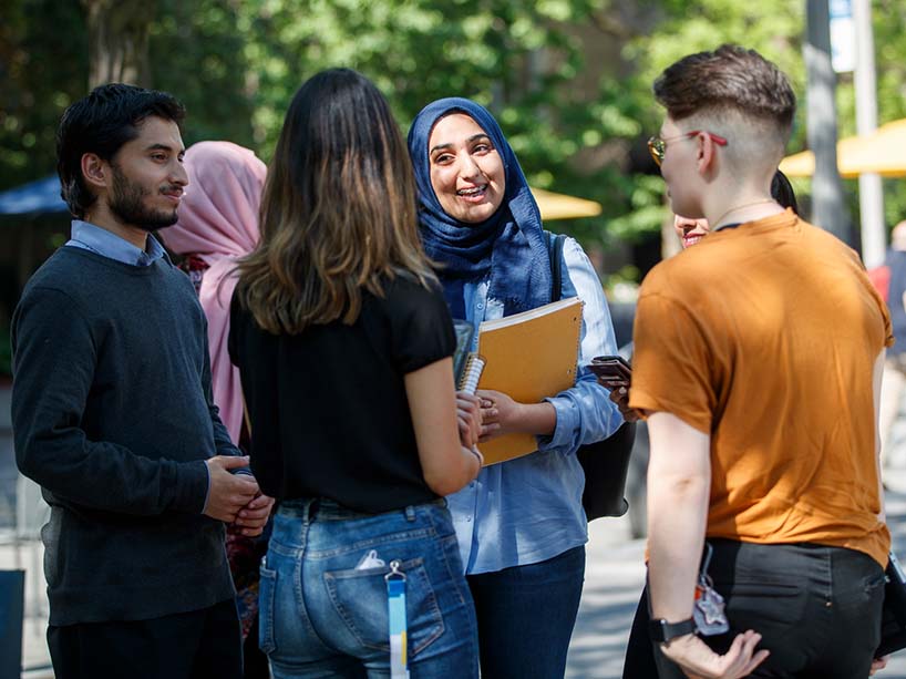 A group of students gathered outside talking.