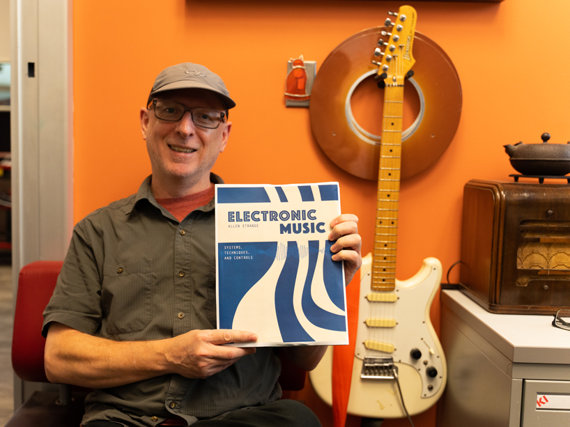 Jason Nolan poses with the new reprinted textbook cover.