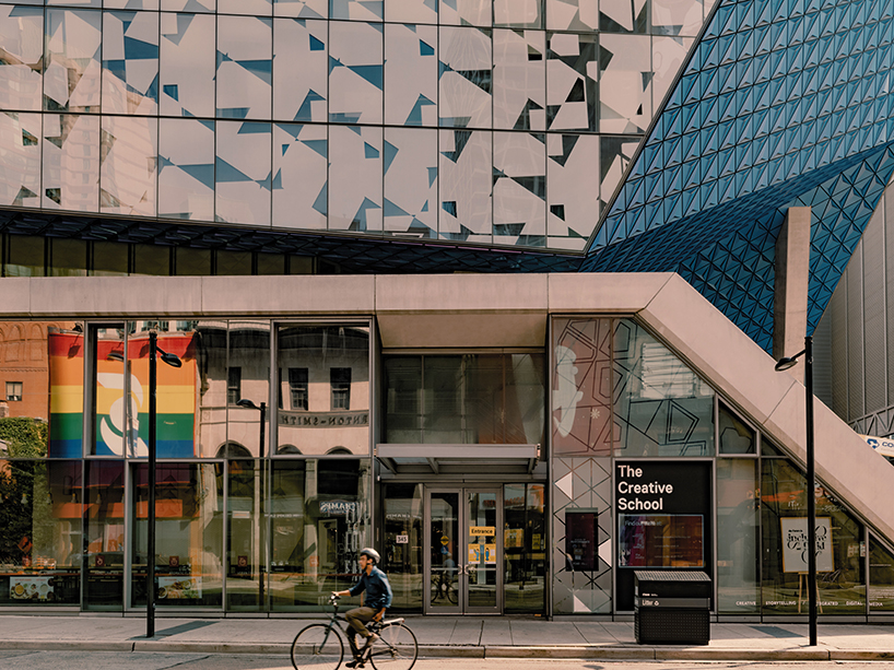 A cyclist rides by a building on campus.