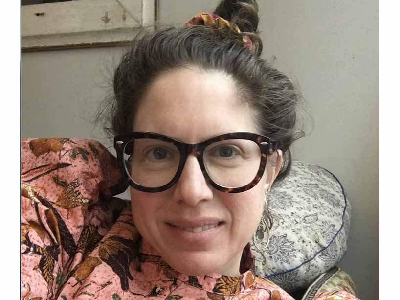 Carolyn Kane in a pink floral top and glasses