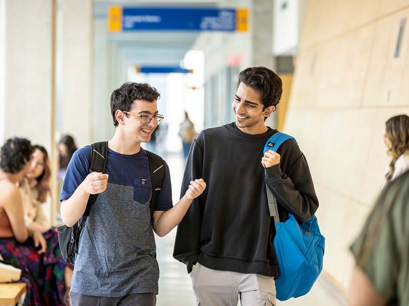 Two students talking and walking at Toronto Metropolitan University. 