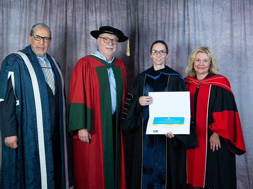 Melody Johnson is pictured at convocation with senior leaders of the university, including President Mohamed Lachemi, holding her gold medal certificate. 