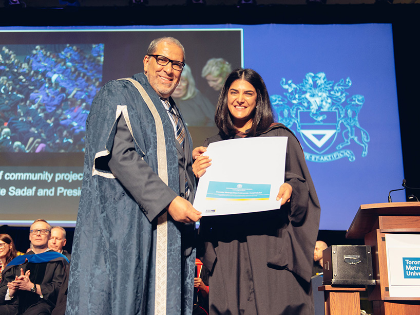 Sadaf Rezakhan Khajeh holds her gold medal certificate while standing next to TMU President Mohamed Lachemi at the Fall 2022 convocation.