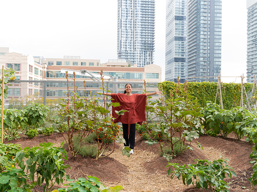 Nicole Austin surrounded by plants in the urban farm on the green roof.