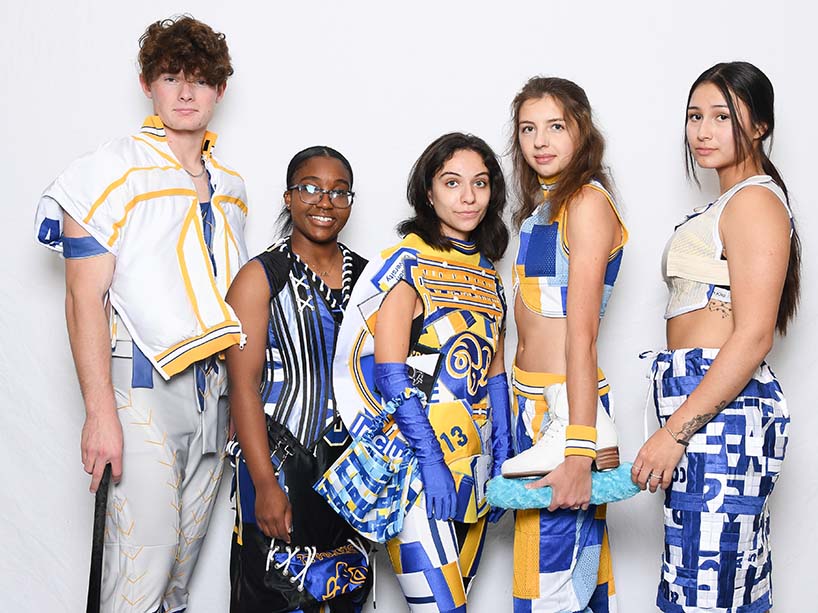 Five TMU Bold student-athletes pose in fashion pieces created for the TMU Upcycled Gear Fashion Show, using materials made from Ryerson and Rams-branded textiles.