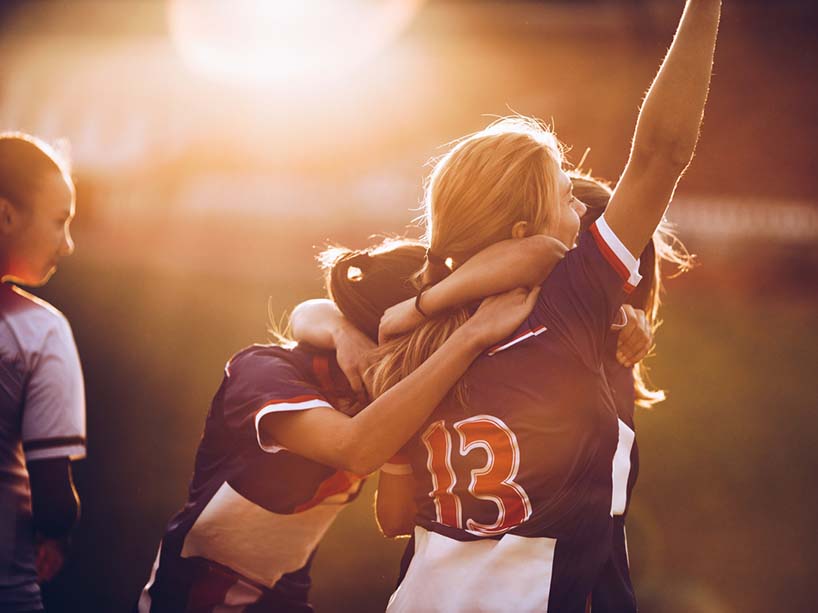 Women soccer players celebrate together