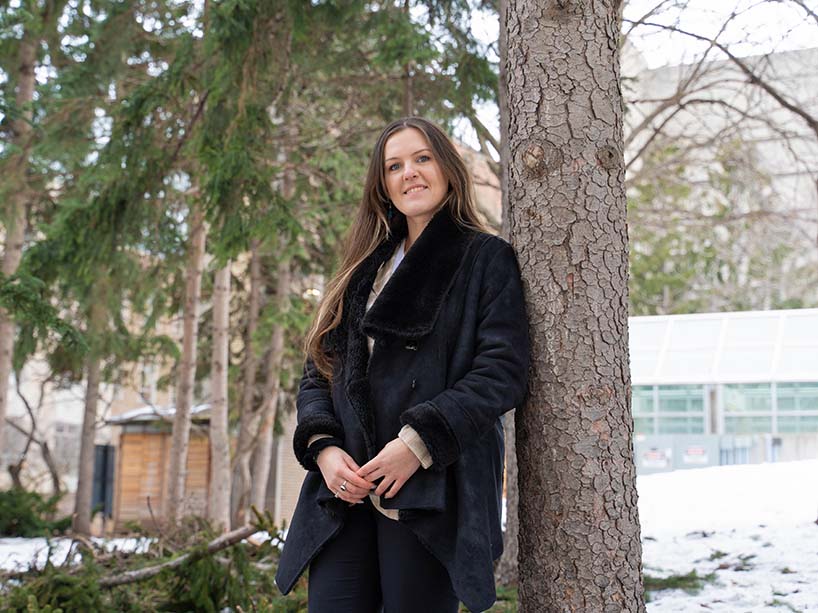 Polina Amaya beside a tree.