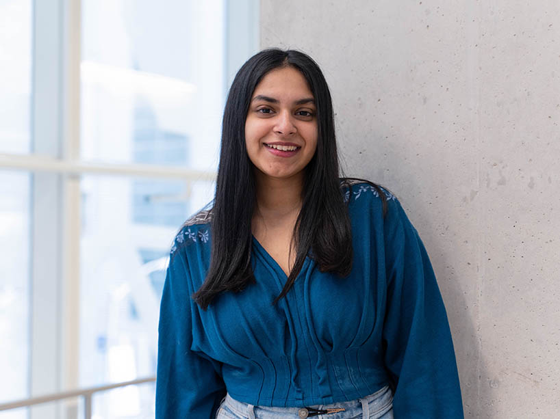 Ria Arora wearing a blue long sleeved shirt.