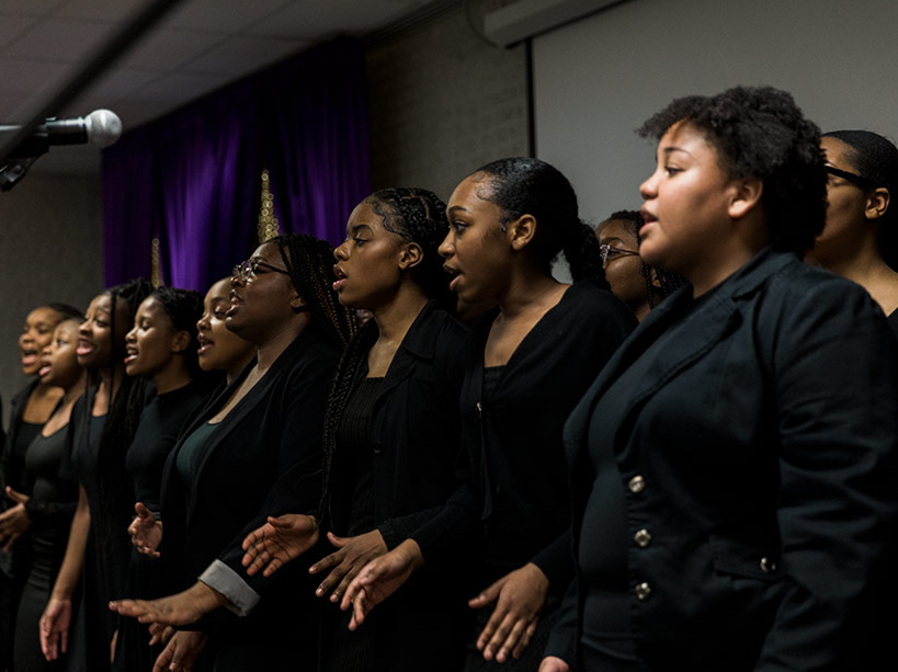 Young Black women standing side by side mid-performance