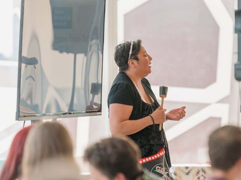 Amy Desjarlais plays a shaker and sings.