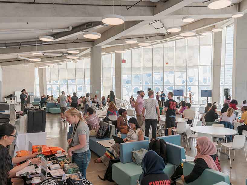 The SLC 8th floor full of TMU community members talking to one another while they wait for programming to start.