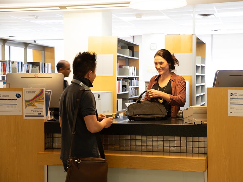A student at the circulation desk in the library. 