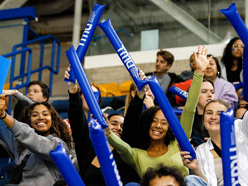A group of people holding TMU branded cheer sticks