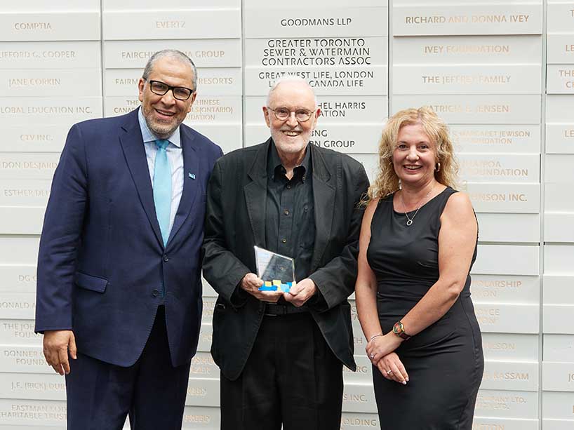 Retired photography professor Dennis Miles, 83, centre, smiles with his award, with President Mohamed Lachemi at left and Roberta Iannacito-Provenzano, provost and vice-president, academic, at right.