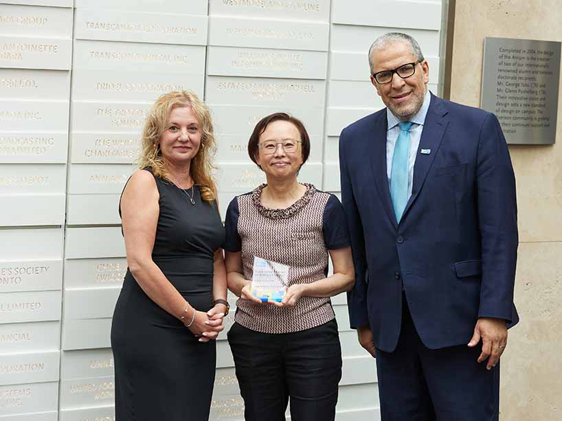 Catherina Hui, centre, smiles and holds her award, with Roberta Iannacito-Provenzano, provost and vice-president, academic, at left, and President Mohamed Lachemi on the right.