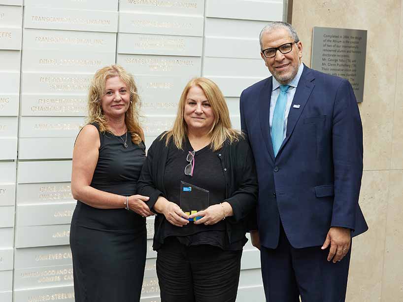 Anna Tassone, centre, smiles with her award, with Roberta Iannacito-Provenzano, provost and vice-president, academic, at left, and President Mohamed Lachemi on the right.