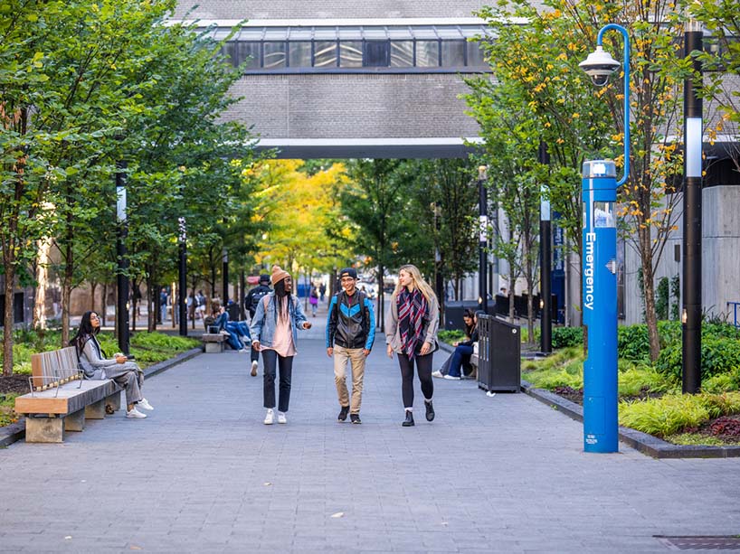 Three students walking on the TMU campus. 