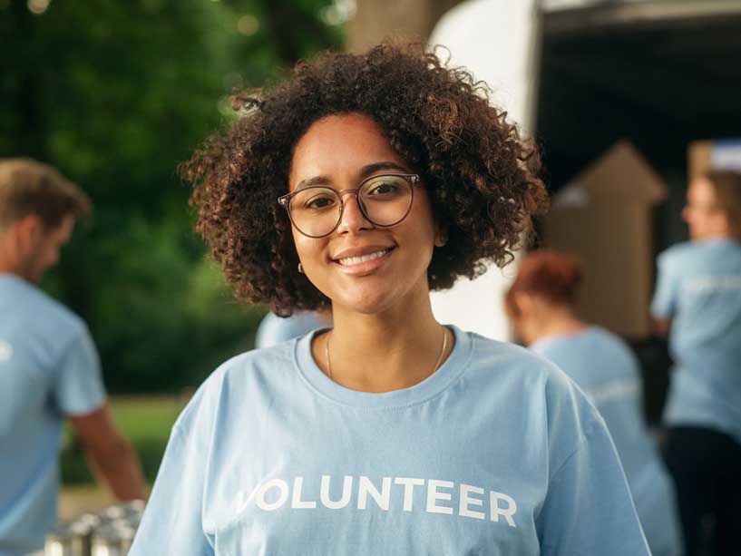 A woman with a shirt on that says ‘volunteer.’