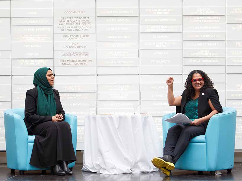 Two women seated across each other.