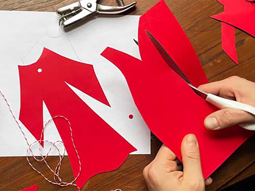 Person cutting red dresses. 