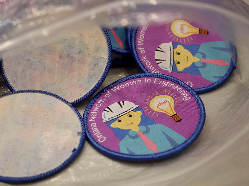 a close-up of a badge has a cartoon drawing of a woman engineer