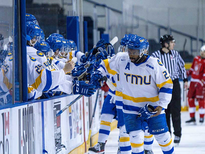 TMU Bold’s Elijah Roberts high-fives his teammates at the consolation game on Sunday, March 17.