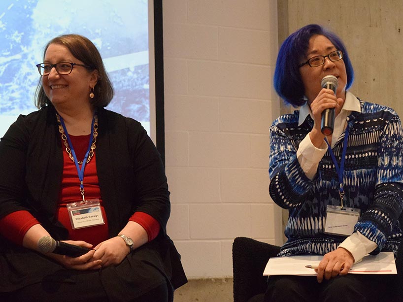 Josephine Wong speaking into a microphone sitting next to Elizabeth Saewyc.