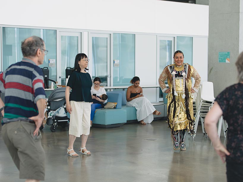 Abby Carpenter wears regalia as she teaches Pow Wow dancing to community members.