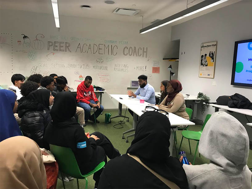 TMU staff facilitating a presentation to a group of high school students.