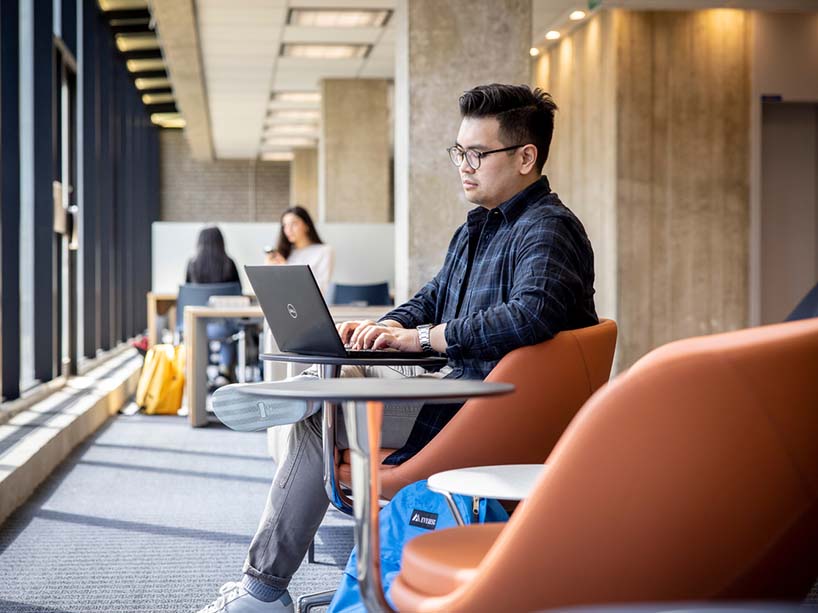 A student working on a laptop in the Library.