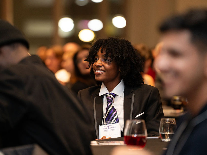 Jeanne Bilap-Nsegbe is engaged and smiling in the audience.