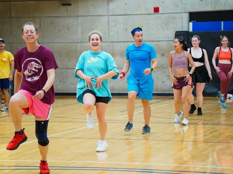 A group of people smiling in a workout class.