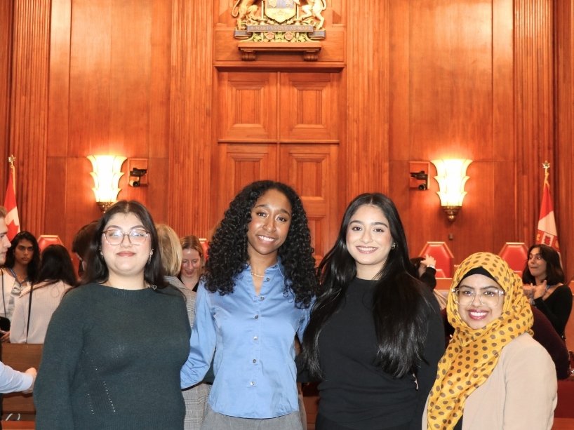 Four young women standing together at the Supreme Court of Canada.