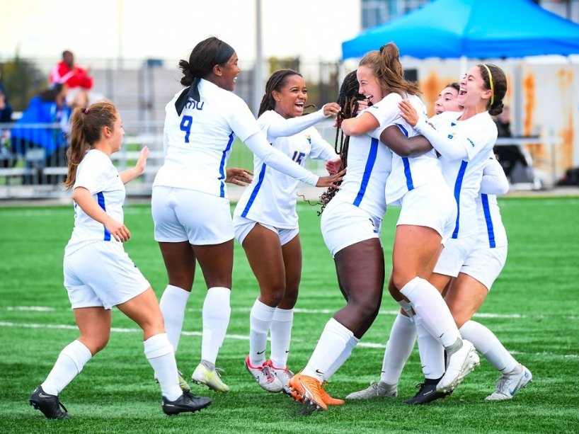Elizabeth Farsang and teammates celebrating during varsity soccer game. (photo credit: Curtis Martin)