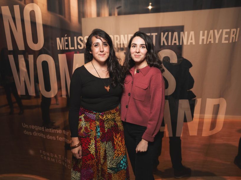  Both Hayeri and Cornet standing in front of a banner that reads “No Woman’s Land”. 