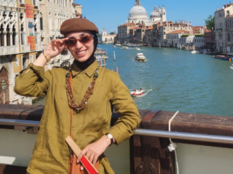 Allataifei standing on a bridge in Venice with the Grand Canal and historic buildings in the background.