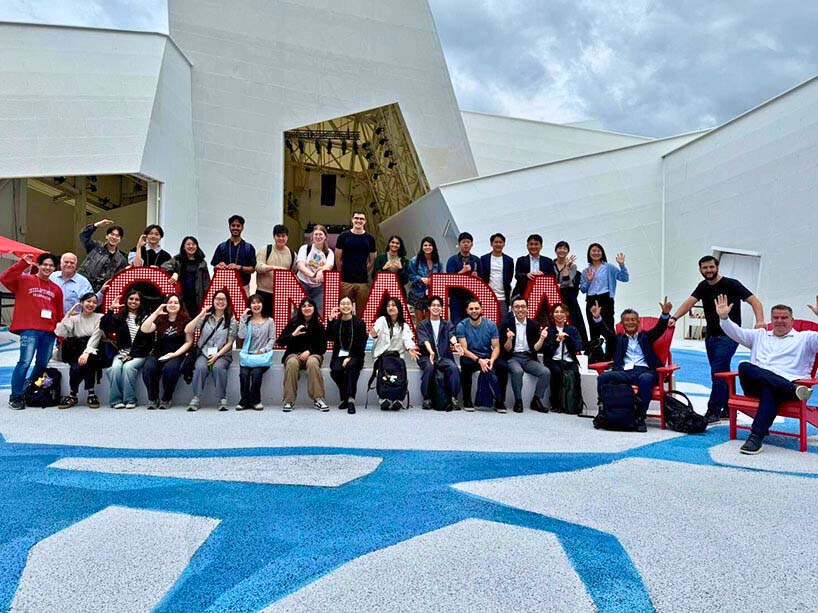 A group of people pose for a photo with a big Canada sign.