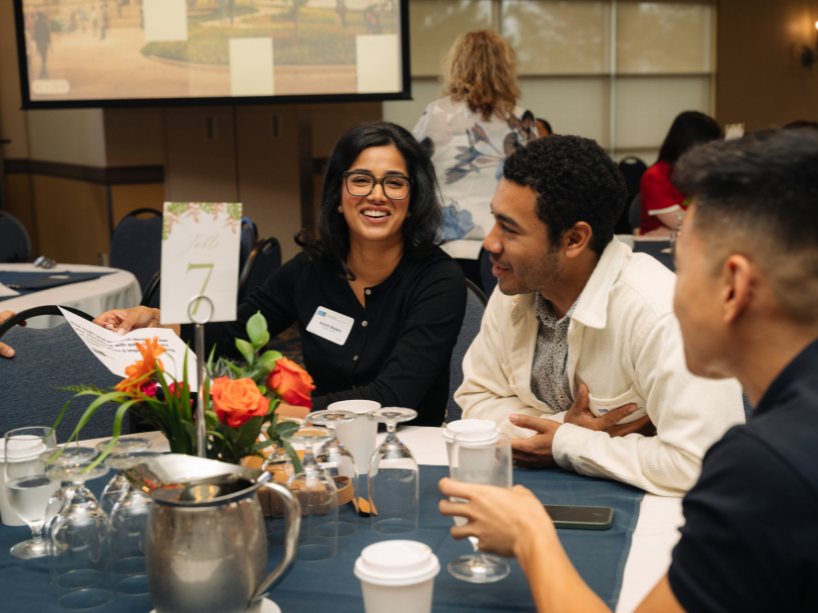 A group of people sitting around tables in discussion during an interactive session.