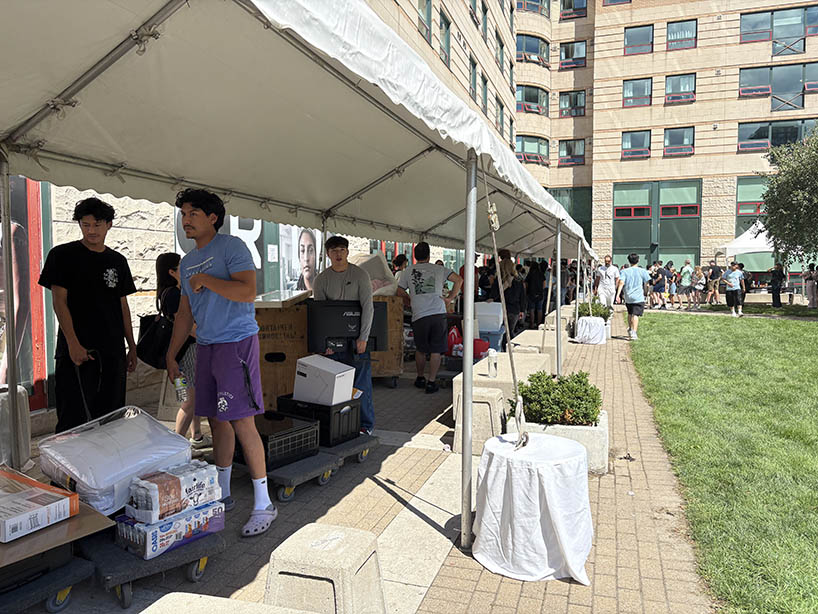 A group of students under a canopy in line to move in to residence.