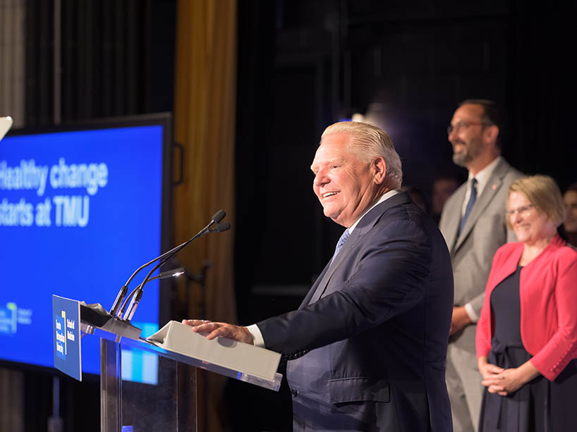 Deputy Premier and Minister of Health Sylvia Jones and Premier Doug Ford speaking at podium. 