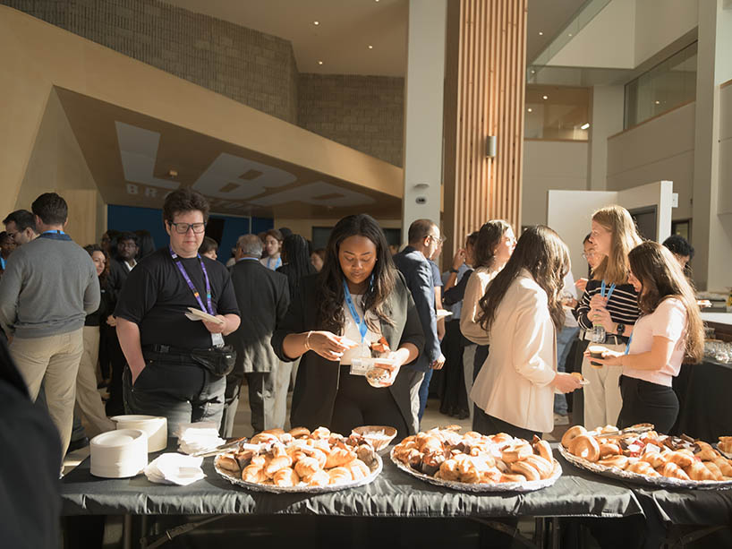 Members of the TMU community mingling in the new school of medicine lobby. 