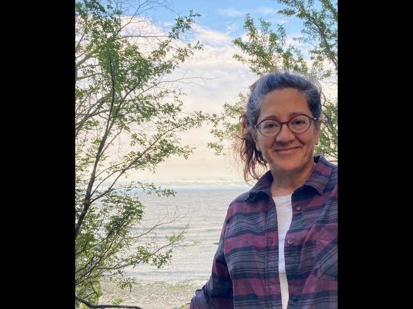 A woman standing by a body of water. 