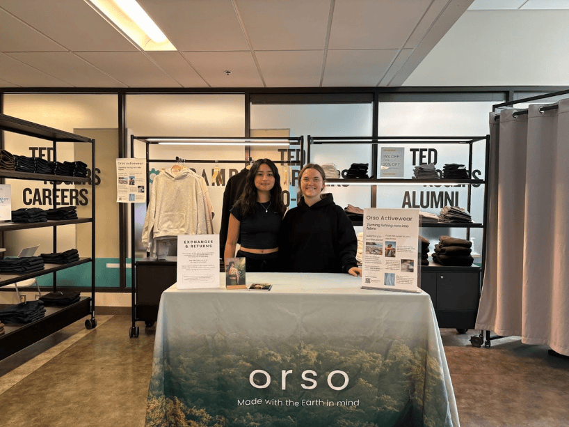 Two women pose in front of the Pop Up Shop.