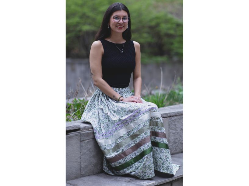 Alacea Yerxa wears a black shirt and green, purple and white ribbon skirt.