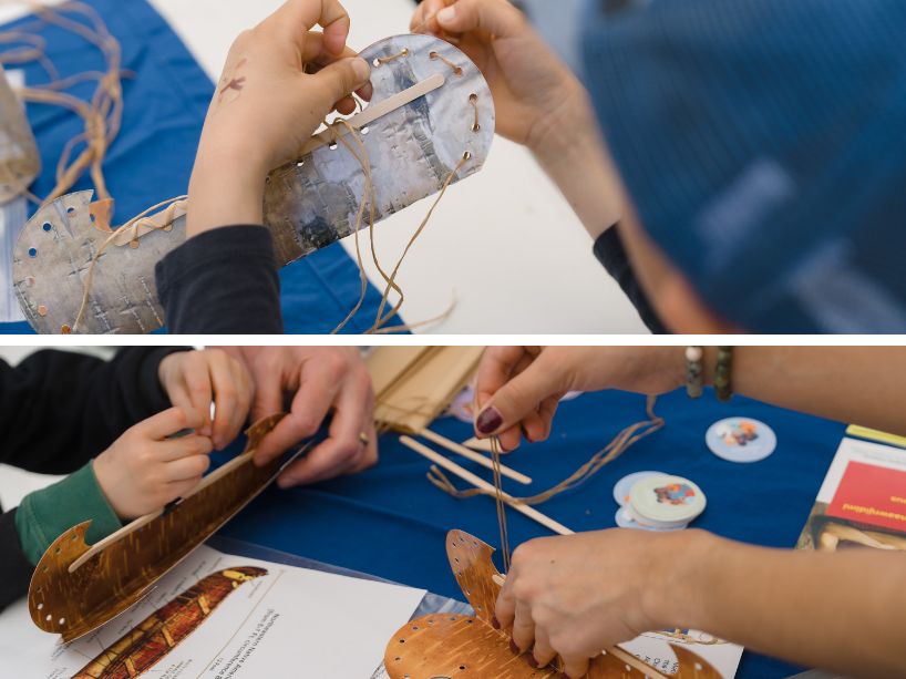 Small model canoes being crafted with birch bark, thread and sticks