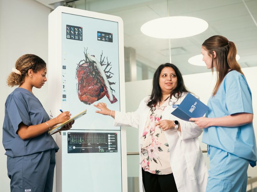 Clinical faculty training future physicians using a virtual screen.