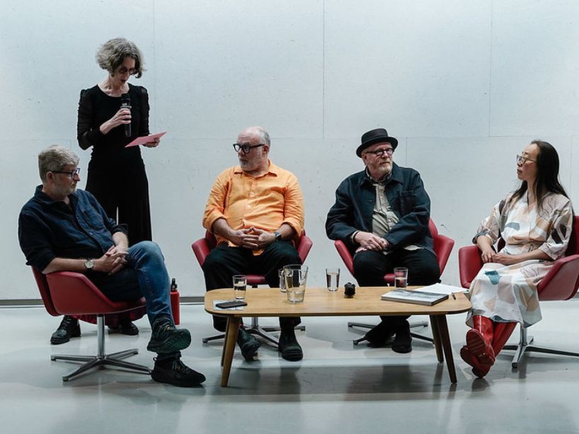 Panelists seated together about to engage in discussion. 