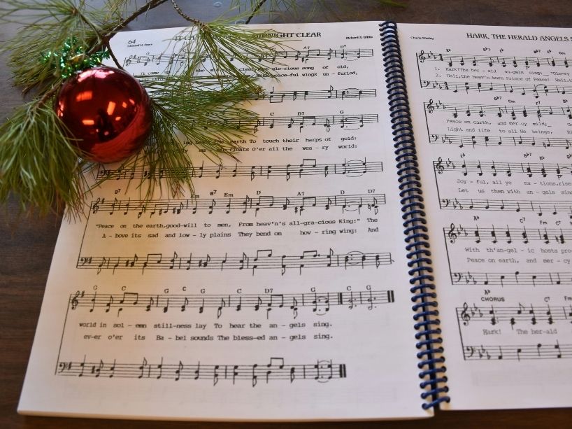 A holiday decoration on the page of a song sheet with musical notes.
