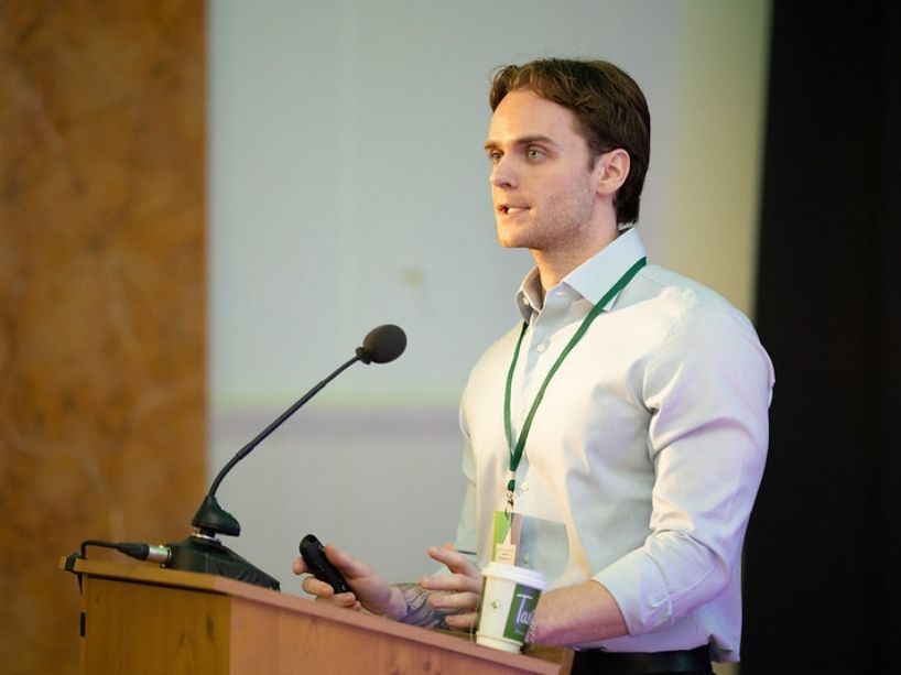 Cameron Schmidt speaking at a podium. 